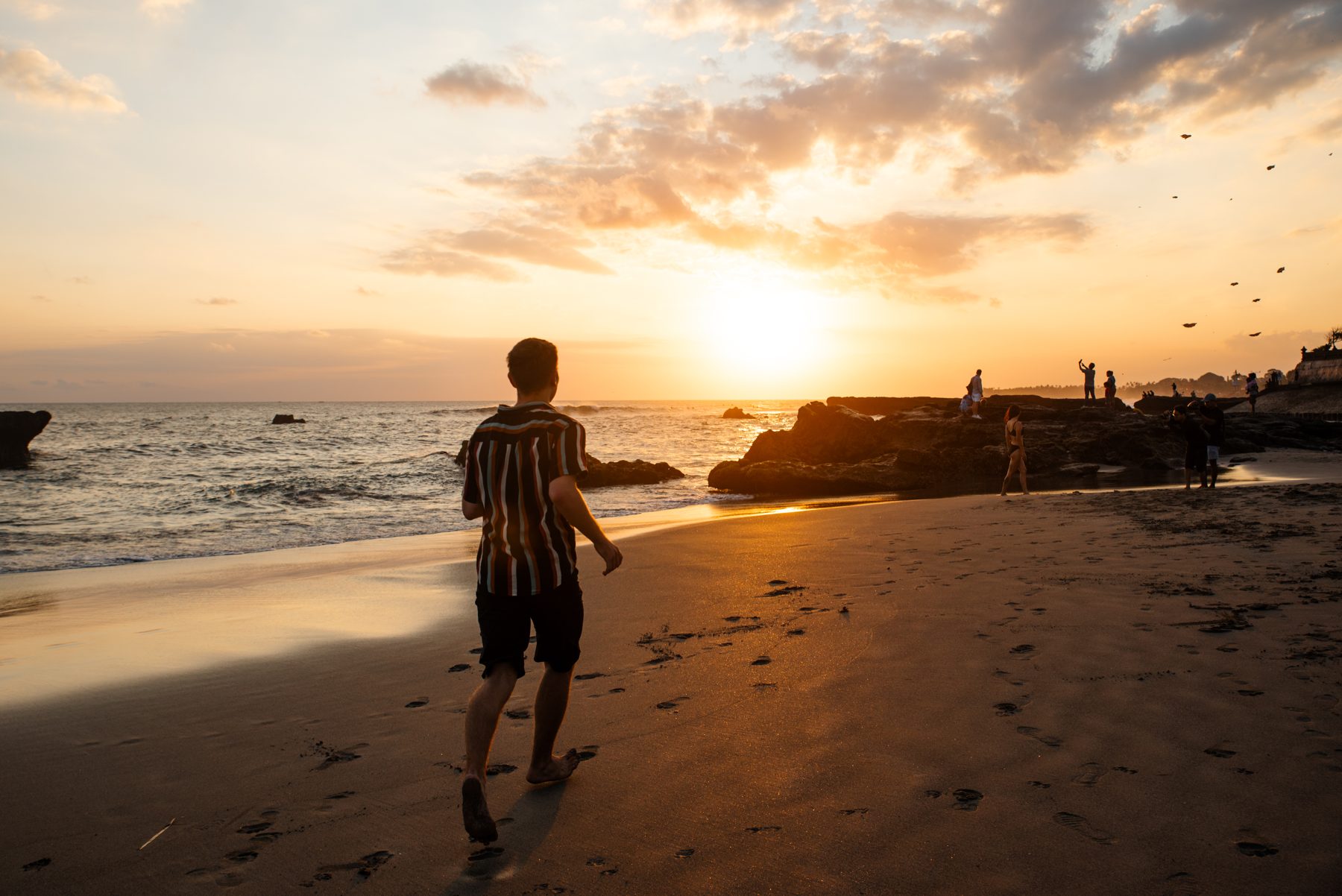 Jonathan geht bei Sonnenuntergang am Strand entlang